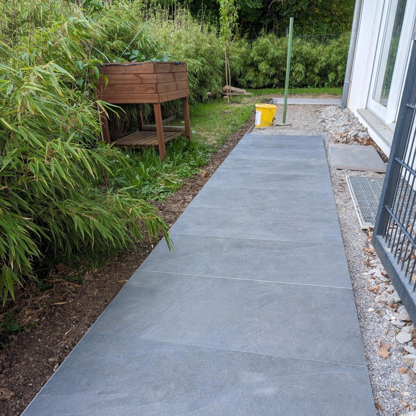 Erste Platten im Splittbett mit Rasenkantenbegrenzung