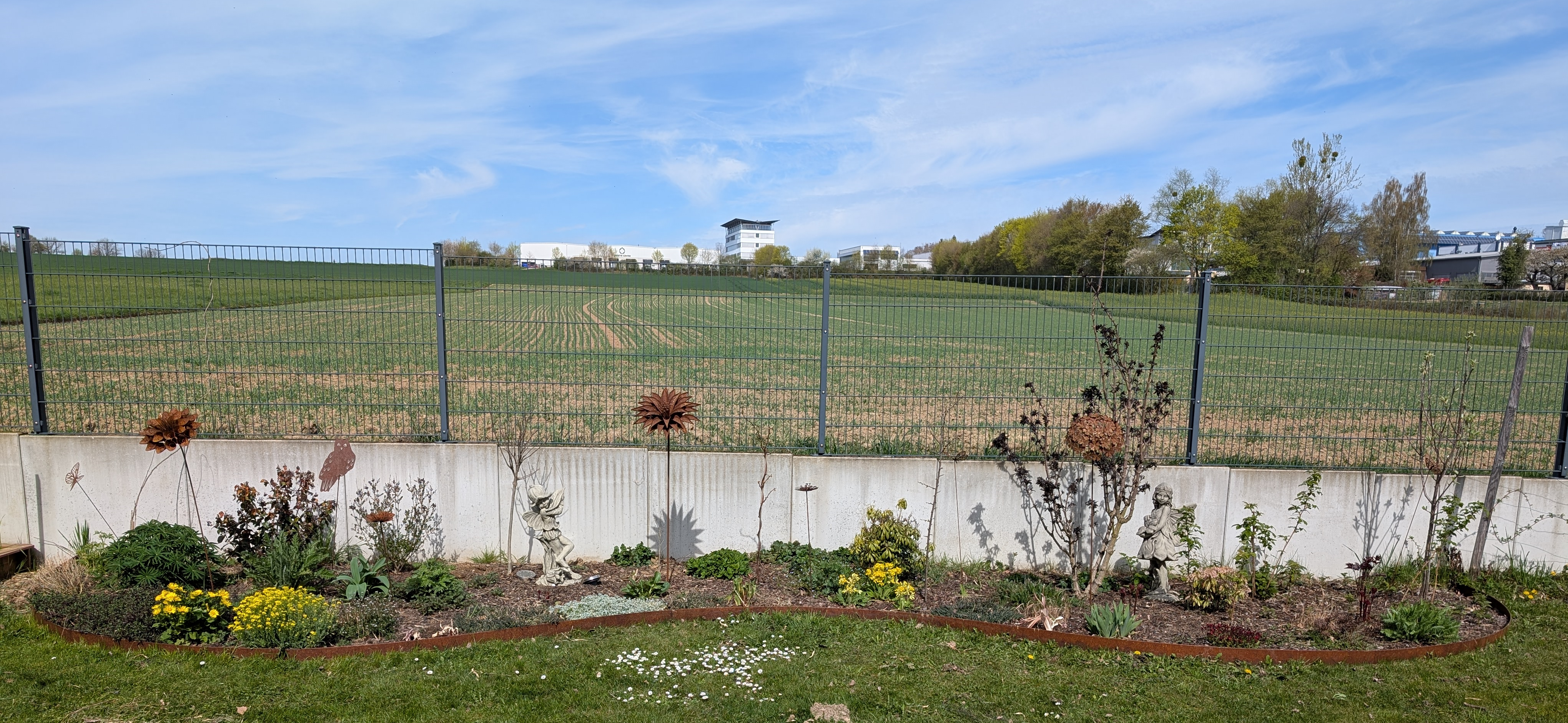 Rasenkante Cortenstahl flexibel in Welle verlegt für ein Staudenbeet mit Edelrost Patina.